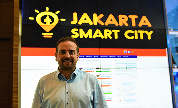 Die Fachkraft Kariem El-Ali steht vor einem Schild mit der Aufschrift "Jakarta Smart City".